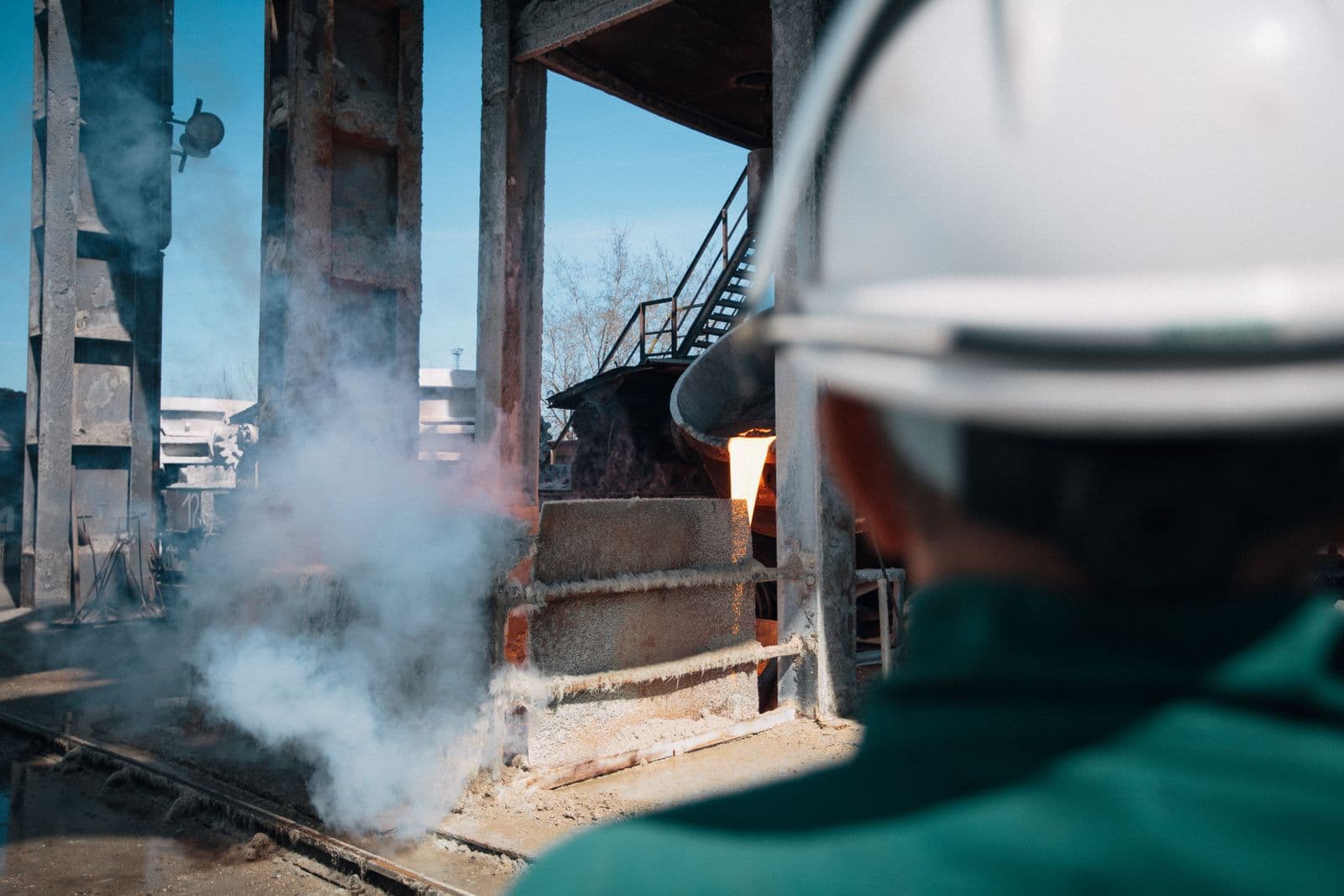 A worker in a hard hat and protective equipment at an industrial plant.